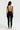 Sleek long jumpsuit black in model back view - JUV
